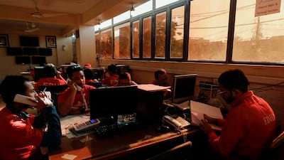 Volunteers with the Edhi Foundation, a social welfare programme, work at darkened desks in Karachi. Reuters