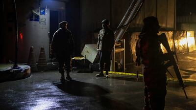Taliban fighters stand guard at the scene of the bomb blast. EPA