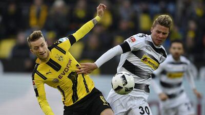 Borussia Dortmund's Marco Reus, left, and Borussia Monchengladbach's Nico Elvedi challenge for the ball during the German Bundesliga match in Dortmund, Germany, Saturday, December 3, 2016. Martin Meissner / AP Photo