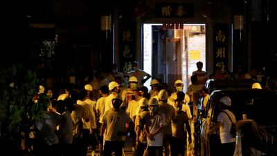 Men in white shirts and carrying poles are seen in Yuen Long after attacking anti-extradition bill demonstrators at a train station. Reuters