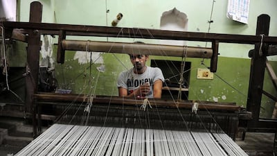An Indian worker weaves a sari, the traditional dress of Indian women, at a handloom factory in Rajapura Varanasi. AFP PHOTO