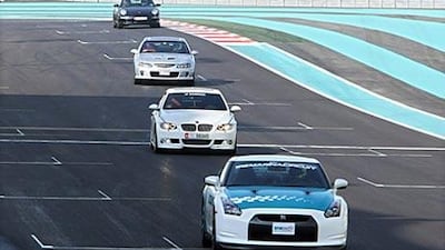 Members of the public are led around the Yas Marina Circuit yesterday after taking up the opportunity to drive their cars on the Formula 1 track.