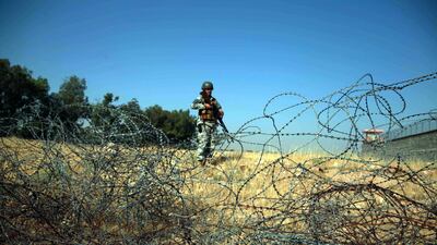 An Afghan security official stands guard on a roadside check point as the Taliban declared a three day ceasefire during the Eid al-Fitr. EPA