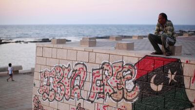 Painter Rafat Askar, 46, rests at the seaside of the rebel-held town of Benghazi, Libya, Thursday, Aug. 18, 2011. The paint on the wall reads: "Libya Free." (AP Photo/Alexandre Meneghini)