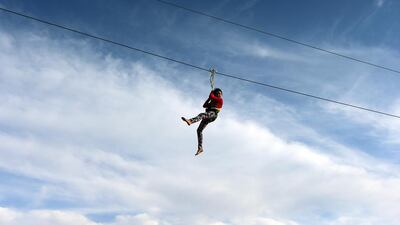A child ziplines over the Abu Dhabi Corniche on the final day of the Mother of the Nation Festival.