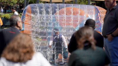 People enjoy the hot weather as they zorb on the canal at Paddington Basin in London. PA