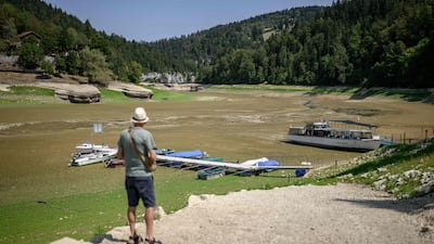 A tourist faces he parched bed of Brenets Lake (Lac des Brenets), part of the Doubs River, a natural border between eastern France and western Switzerland, as central Europe is hit by a new heatwave, in Les Brenets. The river has dried up due to a combination of factors, including geological fissures that drain water underground, below-average rainfall and repeated heatwaves. AFP
