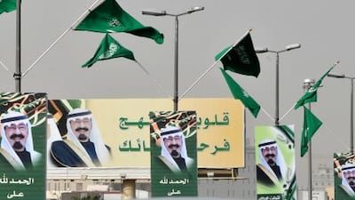 Saudi Arabian flags flutter above pictures of King Abdullah that decorate a street in the capital Riyadh.