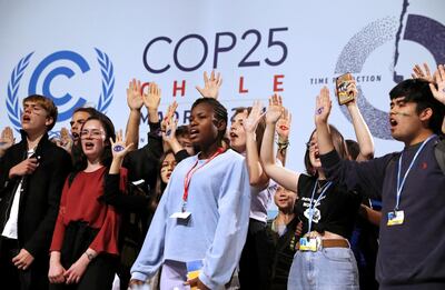 Climate change activist Greta Thunberg is seen behind young climate activists on stage at the High-Level event on Climate Emergency during the UN Climate Change Conference (COP25) in Madrid, Spain December 11, 2019. REUTERS/Susana Vera