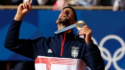 Gold medal winner Novak Djokovic of Serbia celebrates on the podium after beating Spain's Carlos Alcaraz 7-6, 7-6 in the men's singles final at the Paris 2024 Olympics at Roland Garros on August 4, 2024. EPA