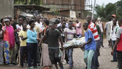 Men carry away a dead body in the Nyakabiga neighbourhood of Bujumbura, Burundi on Saturday 12, 2015. AP Photo