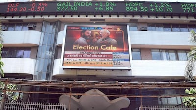 Indian officegoers walk past the Bombay Stock Exchange (BSE) as the digital broadcast shows the 30 share benchmark index SENSEX cross 24,000 points during intra-day trade in Mumbai on May 13, 2014. India's stock market surged for the third straight day to a record high May 13 as exit polls indicated that Hindu nationalist party leader Narendra Modi was on course to become the country's next prime minister. INDRANIL MUKHERJEE / AFP