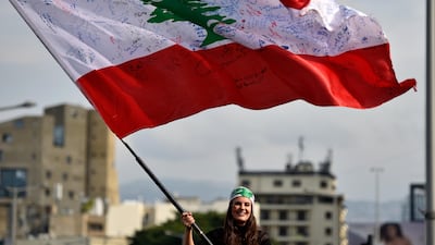A Lebanese protester waves the national flag in Martyrs' Square, Beirut. Wael Hamzeh / EPA