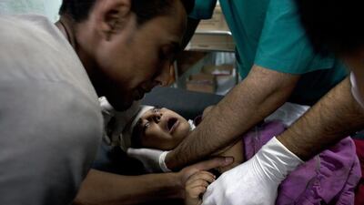 Relatives hold down a Palestinian girl being treated at the Kamal Adwan hospital in northern Gaza after she was injured in Israeli shelling on July 30, 2014, that killed 16 people at a crowded UN school used as refugee shelter. Heidi Levine for The National