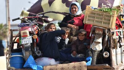 Civilians fleeing the city of Afrin in northern Syria are seen on the back of a pick up truck as they enter the town of Tal Rifaat in the government-controlled part of the northern Aleppo province, on March 18, 2018. George Ourfalian / AFP
