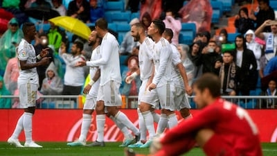 Real Madrid's French forward Karim Benzema celebrates with teammates after scoring his and Madrid's second goal on 31 minutes. AFP