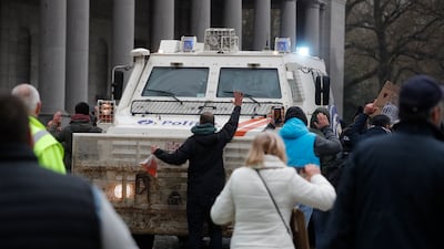 People block a police vehicle. EPA