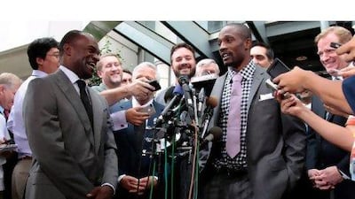 DeMaurice Smith, left, the executive director of the NFL Players' Association, laughs at a comment made by Domonique Foxworth, centre, of the Baltimore Ravens, during a press conference to confirm the end of the NFL lockout.