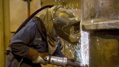 A grinder works on a freshly cast piece of steel. Oli Scarff / AFP