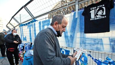 A man lights candles as fans gather outside the San Paolo stadium to commemorate Diego Maradona. AP Photo