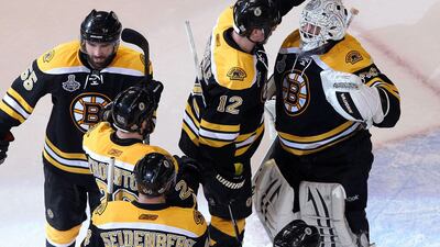 Tim Thomas celebrates with his teammates after defeating the Vancouver Canucks.