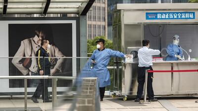 People queue for a swab test in Shanghai's Lujiazui financial district on Wednesday. Bloomberg