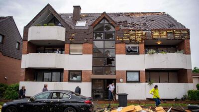 Residents clear debris in front of an apartment building. AFP