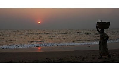 A fisherwoman walks along the beach at Anjuna.