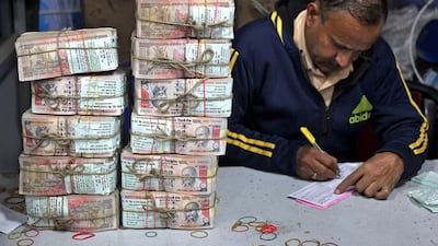 An employee fills a form after counting stacks of old 1,000 Indian rupees inside a bank in Jammu. Mukesh Gupta / Reuters