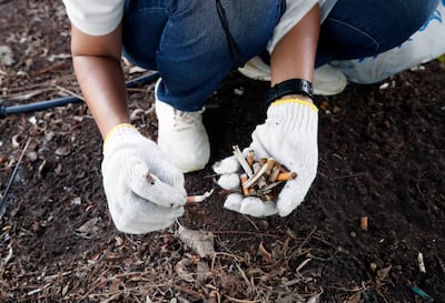 A participant picks up cigarette waste to compete during a litter picking sport competition in Bangkok, on July 2, 2023. EPA