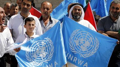 Palestinians hold placards alongside the United Nations (UN) and the Palestinian flags during a protest in the West Bank city of Hebron. EPA