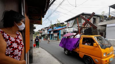 Catholic church staff riding a truck take a wooden cross around a quarantined community to mark Good Friday in Quezon City, Metro Manila, Philippines. EPA
