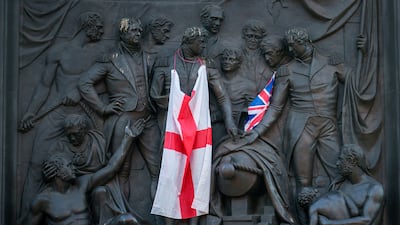 Flags draped on a bas relief at the bottom of Nelson's Column during the Unite The Kingdom rally in central London. Getty Images