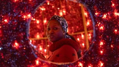 A woman stands among Christmas light decorations in Dakar, Senegal. EPA