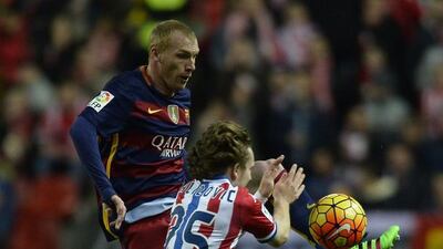 Barcelona’s French defender Jeremy Mathieu (L) jumps for the ball with Sporting Gijon’s Croatian forward Alen Alilovic during the Spanish league football match Real Sporting de Gijon vs FC Barcelona at El Molinon stadium in Gijon on February 17, 2016. AFP PHOTO / MIGUEL RIOPA