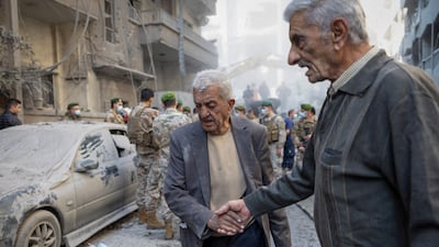 A man walks away from the site covered in dust after the air strike. Reuters