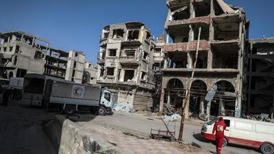 Volunteers with Syrian Arab Red Crescent (SARC) walk to unload aid trucks in Douma, in Eastern Ghouta, Syria, on March 5, 2018.Mohammed Badra / EPA