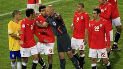 Howard Webb, centre, asks Egypt's Ahmed al Muhamadi, second from left, to leave the field after giving him a red card.