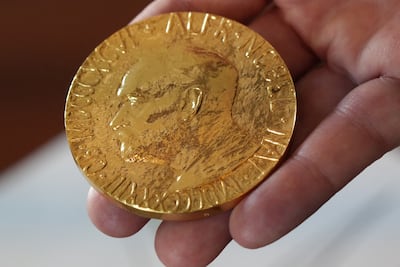 An employee of the Norwegian Nobel Institute holds a replica of a Nobel Peace Medal in Oslo, Norway. Reuters