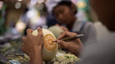A Thai girl carves floral patterns into a melon during a fruit and vegetable carving competition in Bangkok. Robert Schmidt / AFP