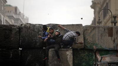 Protesters hide from security forces, unseen, near Tahrir Square, Cairo. Khalil Hamra / AP