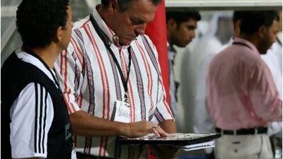 Abel Braga, coach of Al Jazira club, checks his squad list before the match against arch-rivals Al Wahda club.