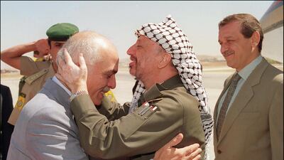 Yasser Arafat, centre, kisses the head of King Hussein as Yasser Abed Rabbo, the chief of the PLO information department looks on, during Arafat's arrival at Marka airport in September 1993 in Amman. AFP