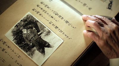 Yoshiomi Yanai looks at his last will and testament with his portrait photo. About one in every five kamikaze planes hit an enemy target.