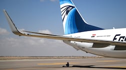 A visitor sits in the shadow of an aircraft at the Egypt International Air Show in September 2024. EPA