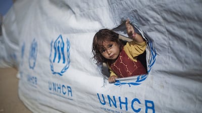 A displaced Pakistani girl looks out from a hole in a fence before departing Yar Hussain UNHCR camp in Chota Lahore. Getty Images