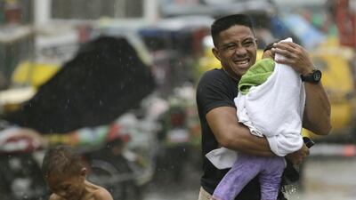 Residents at the slum community of Baseco evacuate to safer grounds at the onslaught of Typhoon Rammasun, locally known as Glenda, which battered Manila on July 16, 2014. Bullit Marquez / AP Photo