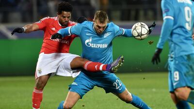 Benfica’s defender Eliseu (L) vies for the ball with Zenit’s forward Artem Dzyuba during the second-leg round of 16 Uefa Champions League football match FC Zenit vs SL Benfica at the Petrovsky stadium in St Petersburg on March 9, 2016. AFP PHOTO / KIRILL KUDRYAVTSEV