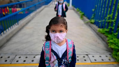 Children wear face masks as they queue keeping distance as a preventive measure against the spread of the coronavirus, COVID-19, at the Paul Valery French School in Yumbo, Valle del Cauca department, Colombia. Some children started attending classes in Colombia complying with a biosecurity protocol, wearing face masks and maintaining social distance some days a week. AFP
