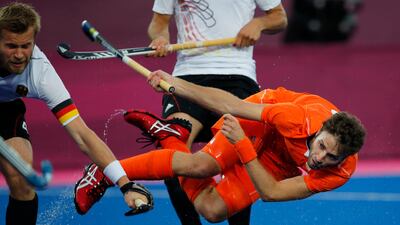 The Netherlands' Rogier Hofman plays a shot as Germany's Maximilian Mueller, left, tries to block in the men's field hockey gold medal match. Eranga Jayawardena/AP Photo
